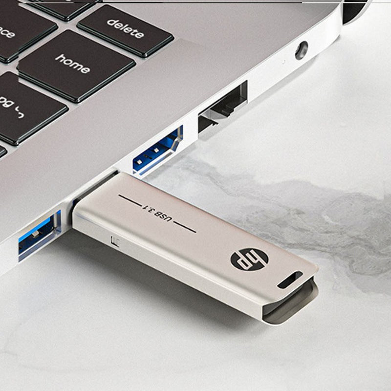 128GB HP USB 3.1 Flash Drive inserted in laptop USB port, showcasing high-speed metal USB stick design.